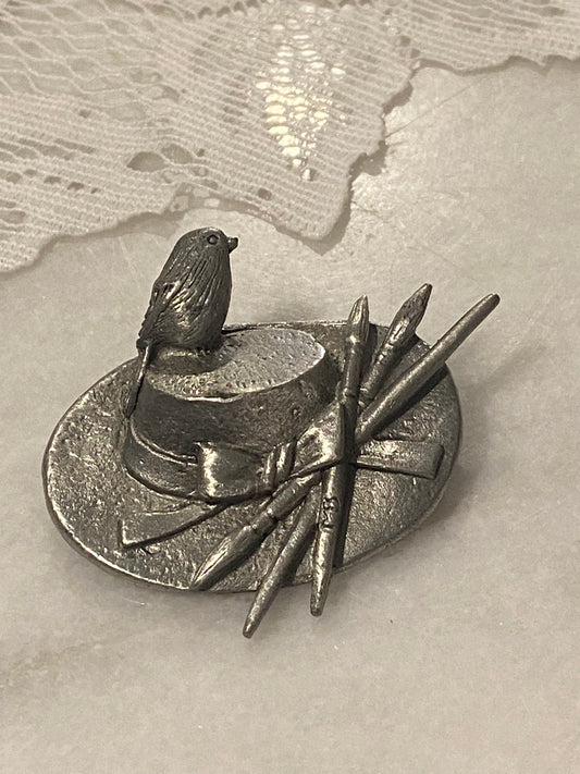 Pewter Hat Brooch with Bird, Bow and Paintbrushes by Marjolein Bastin